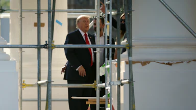 Donald Trump sticks his tongue out while touring the construction on the White House