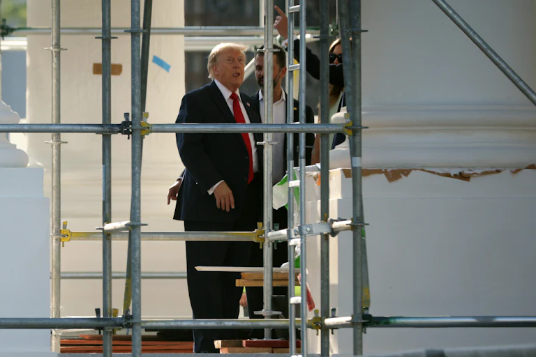Donald Trump sticks his tongue out while touring the construction on the White House