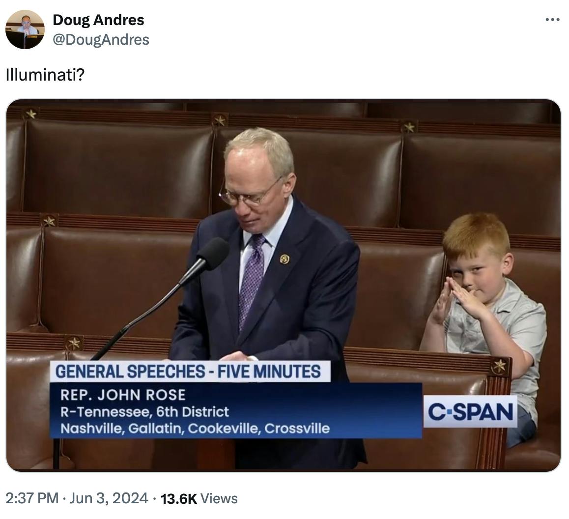 Tweet screenshot, image shows child making a triangle symbol as his dad John Rose speaks