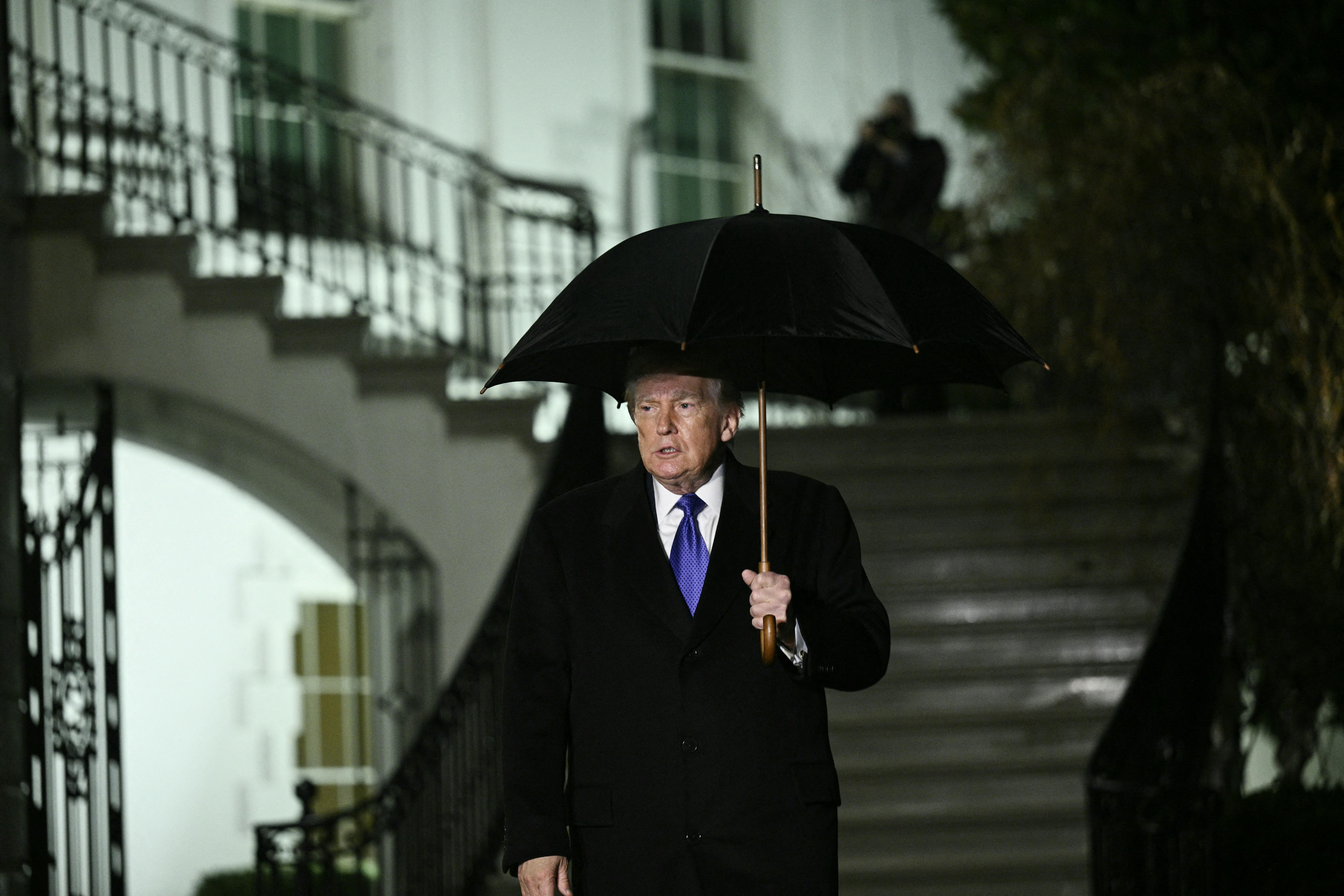 Donald Trump walks to speak to reporters as he departs from the South Lawn of the White House.