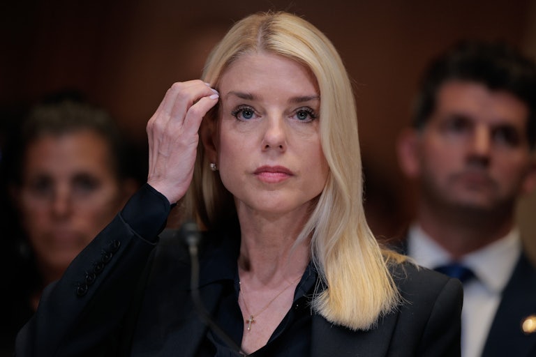 Pam Bondi brushes her hair with her hand as she is grilled by Congress