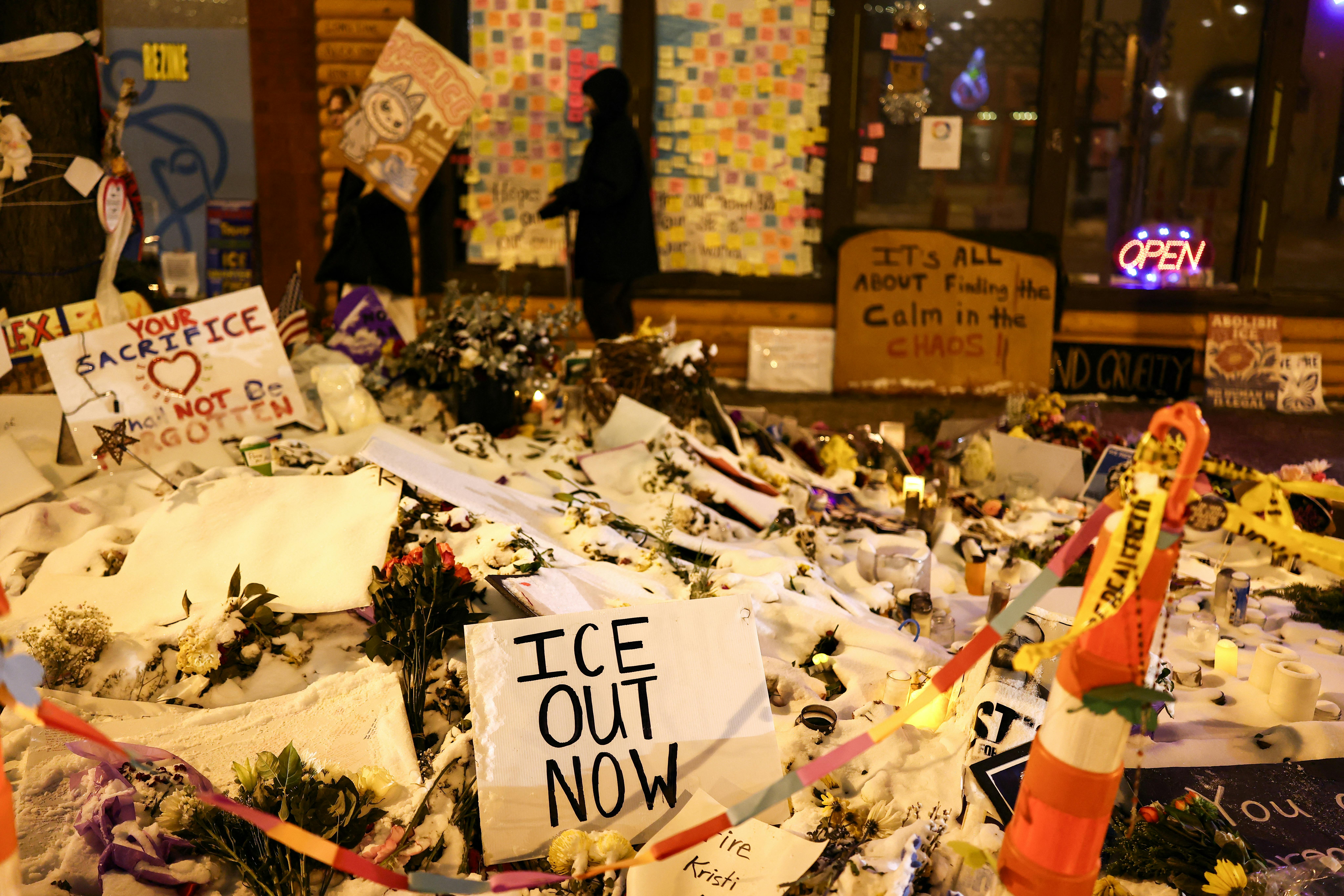 A sign that says, "ICE out now" stands at a memorial for Alex Pretti