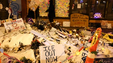 A sign that says, "ICE out now" stands at a memorial for Alex Pretti