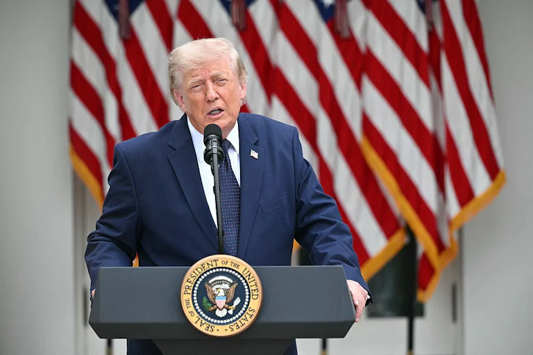 Donald Trump stands at a podium and squints