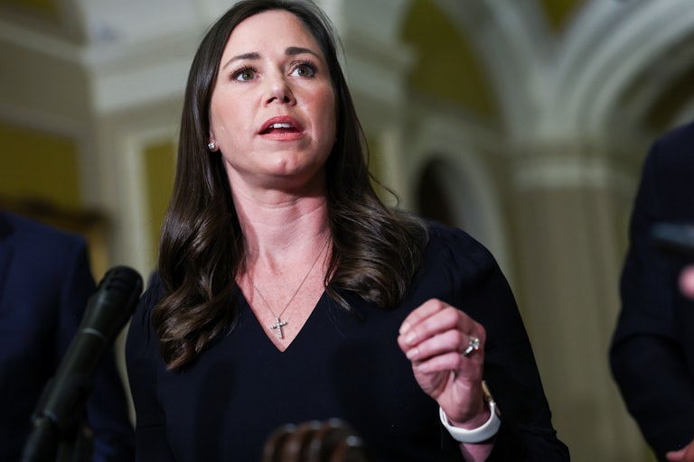 Senator Katie Britt gestures while speaking at a podium