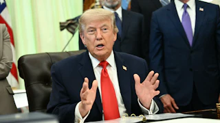 President Donald Trump speaking at his desk in the Oval Office of the White House