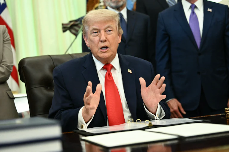 President Donald Trump speaking at his desk in the Oval Office of the White House