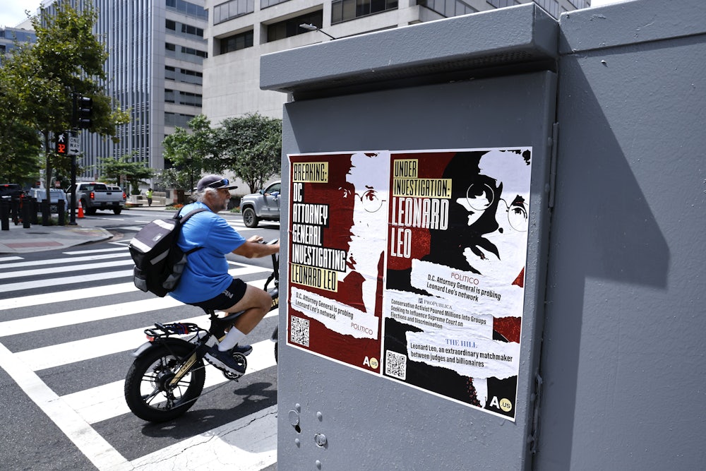 Two posters read "Breaking: D.C. attorney general investigating Leonard Leo" and "Under investigation: Leonard Leo."