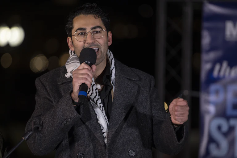 Mohsen Mahdawi speaks into a microphone during an event