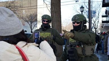 Bureau of Prisons officers near the scene in Minneapolis where a man was shot dead by federal agents