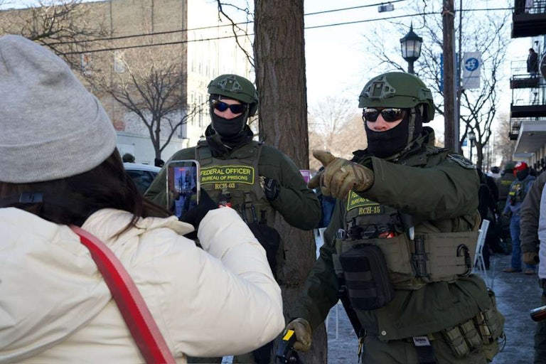 Bureau of Prisons officers near the scene in Minneapolis where a man was shot dead by federal agents