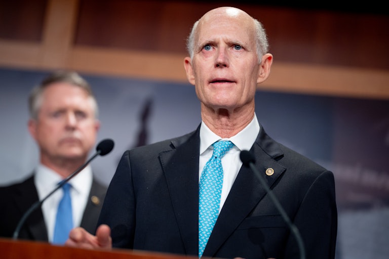 Senator Rick Scott speaking at a lecturn (he looks weird)