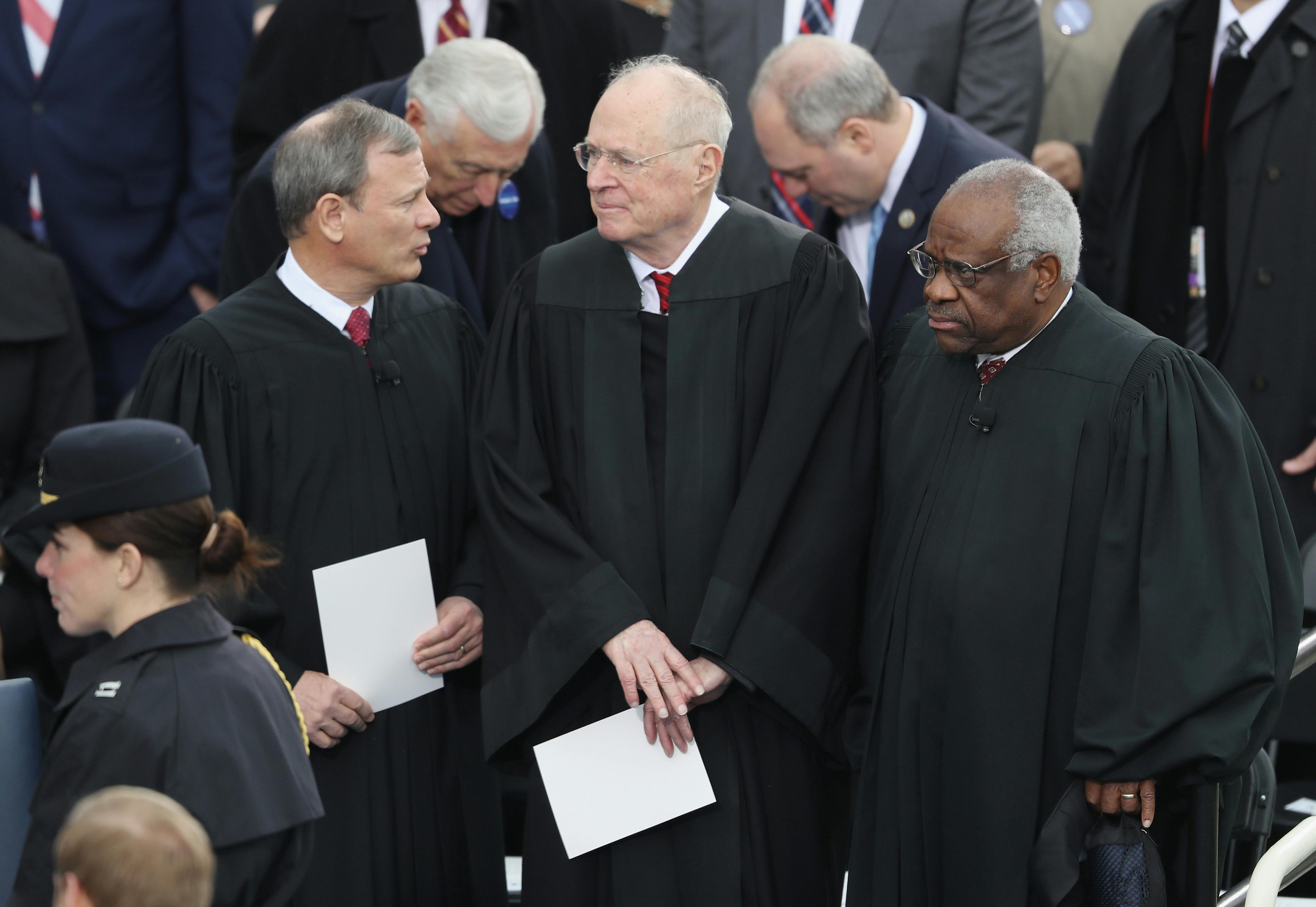 Justice Anthony Kennedy stands between Chief Justice John Roberts and Justice Clarence Thomas at President Donald Trump's inauguration.