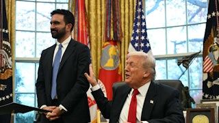 Donald Trump smiles and pats Zohran Mamdani on the arm while sitting at his desk in the Oval Office