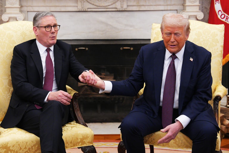U.K. Prime Minister Keir Starmer holds hands with Donald Trump while speaking during a joint press conference in the Oval Office