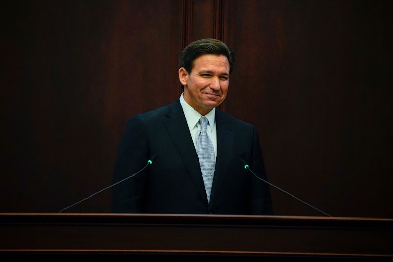Florida Governor Ron DeSantis smiles at a podium