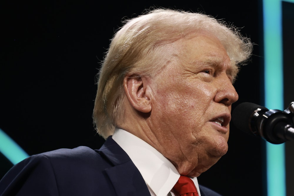 Donald Trump frowns while speaking into a microphone