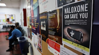 A sign for Naloxone hangs on a wall