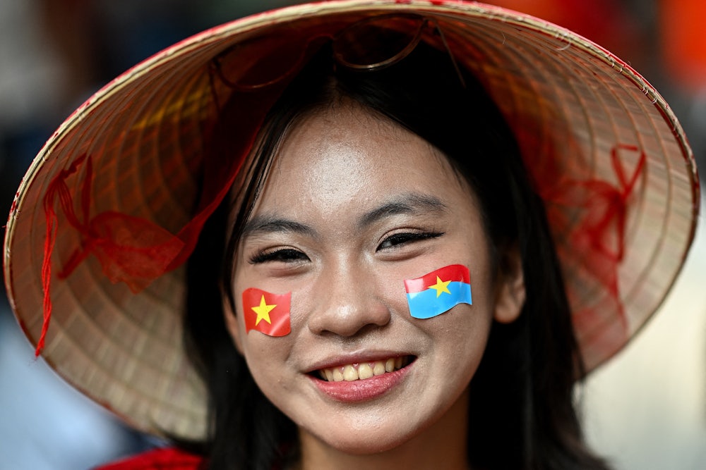 A woman wears stickers of Vietnam’s national flag and the Vietnam Liberation Force flag on her face