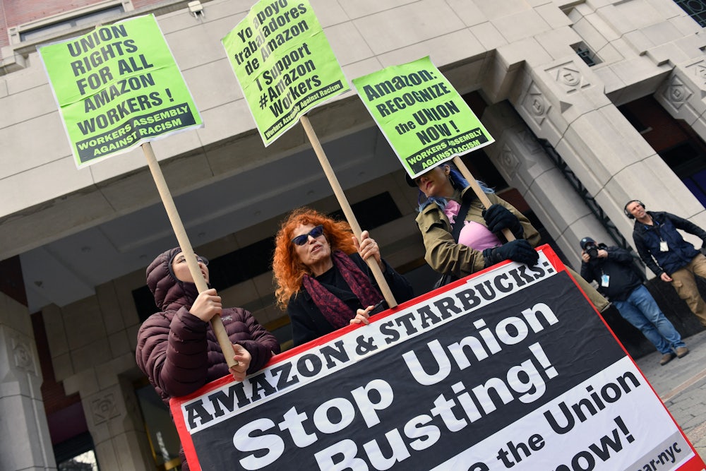 Three demonstrators hold signs supporting unionization of Amazon workers.
