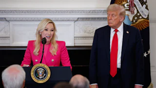 Paula White-Cain speaks at a podium. Donald Trump stands next to her.