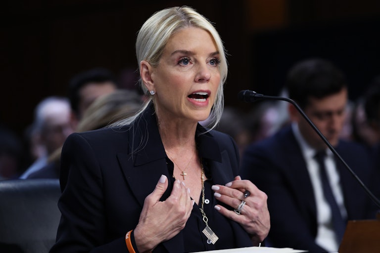 Attorney General Pam Bondi speaks animatedly in a Senate hearing while ushering both hands to herself.