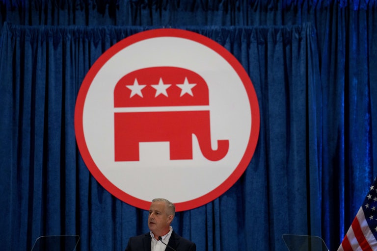 Michael Whatley speaks in front of the RNC logo