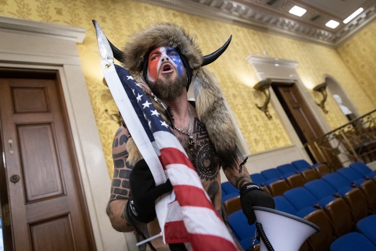 Jacob Chansley, the self-described "QAnon Shaman," shouts while standing in the U.S. Capitol during the January 6 riot