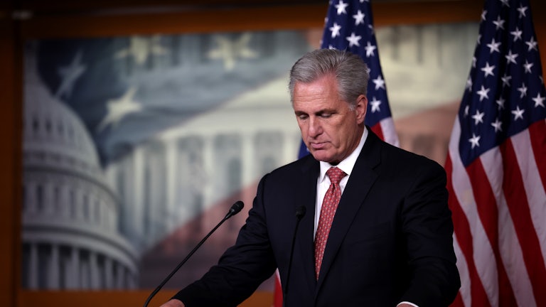 House Minority Leader Kevin McCarthy stands behind a lectern looking down.