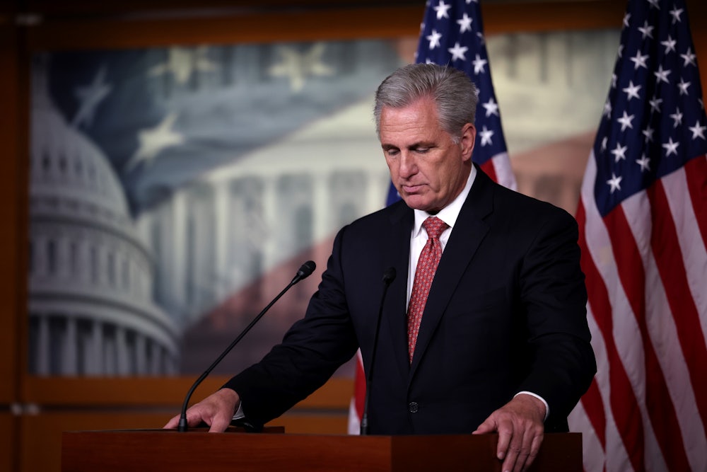House Minority Leader Kevin McCarthy stands behind a lectern looking down.