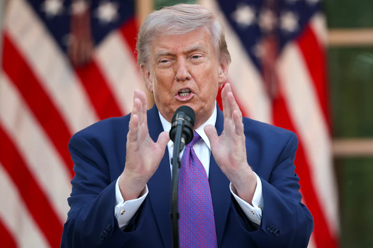 Donald Trump gestures while speaking at a microphone