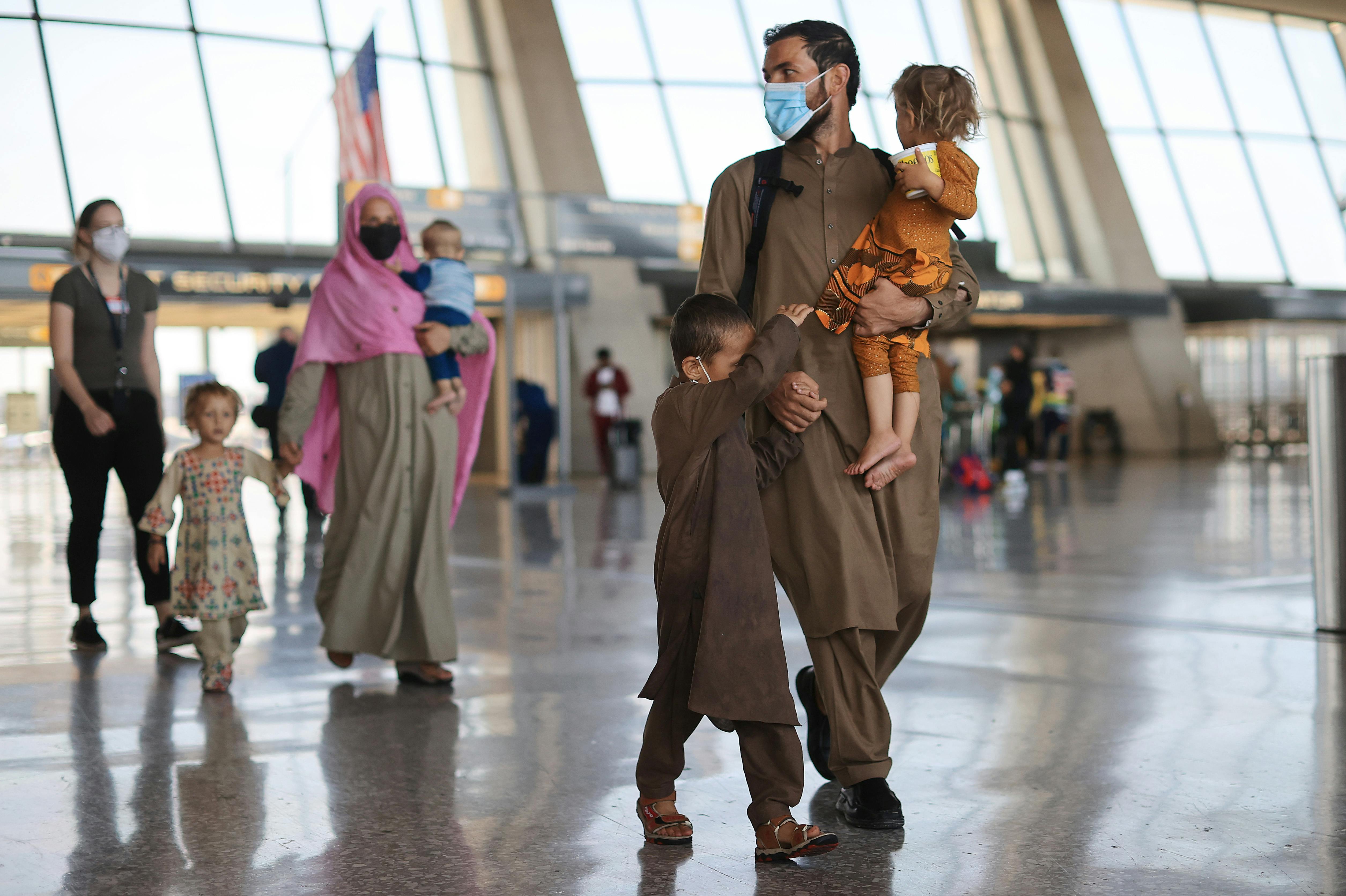 Refugees arrive at Dulles International Airport after being evacuated from Kabul following the Taliban takeover of Afghanistan. 