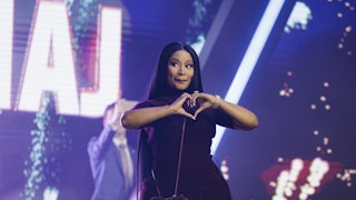 Nicki Minaj makes a heart gesture with her hands while on stage at the Turning Point USA conference.