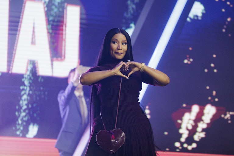 Nicki Minaj makes a heart gesture with her hands while on stage at the Turning Point USA conference.