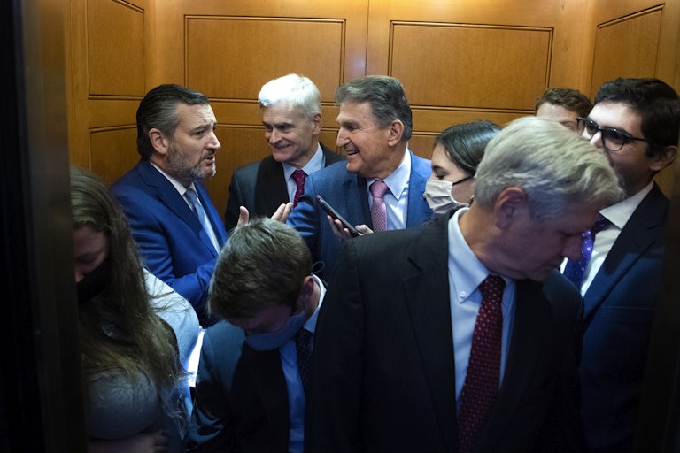 Joe Manchin and Ted Cruz stand in a crowded elevator