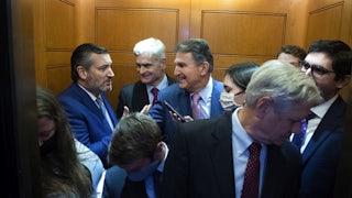 Joe Manchin and Ted Cruz stand in a crowded elevator