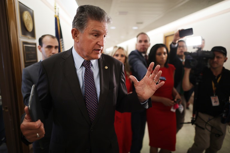 Senator Joe Manchin speaks, as press surrounds him in the Capitol