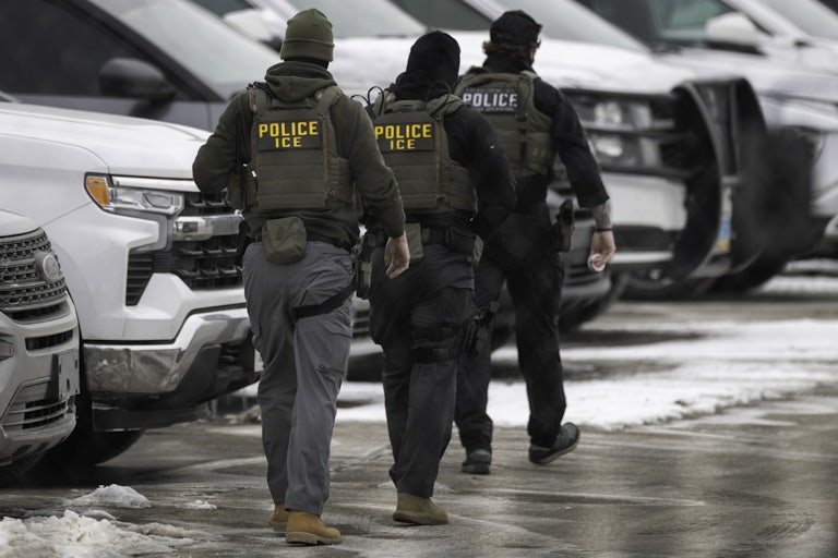 Federal immigration agents walk in a parking lot in Minneapolis, Minnesota