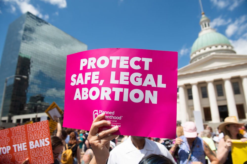 Protesters hold signs as they rally in support of abortion rights in St. Louis, Missouri.