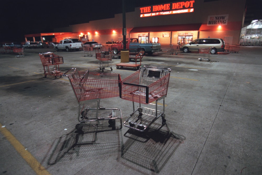 Mostly empty parking lot, stewn with carts at the Home Depot, for feature story about Home Depot store that is open 24 hours. Shopping carts, not cars, take up parking spots in a vacated lot.