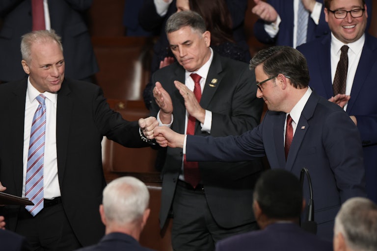 Mike Johnson shakes hands with Steve Scalise, surrounded by clapping colleagues.