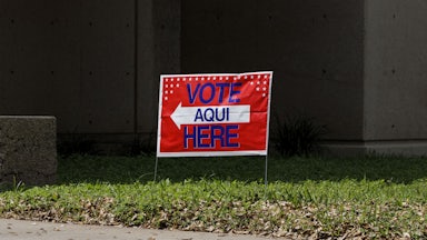 A sign outside a polling station that says, "Vote Aqui/Here"