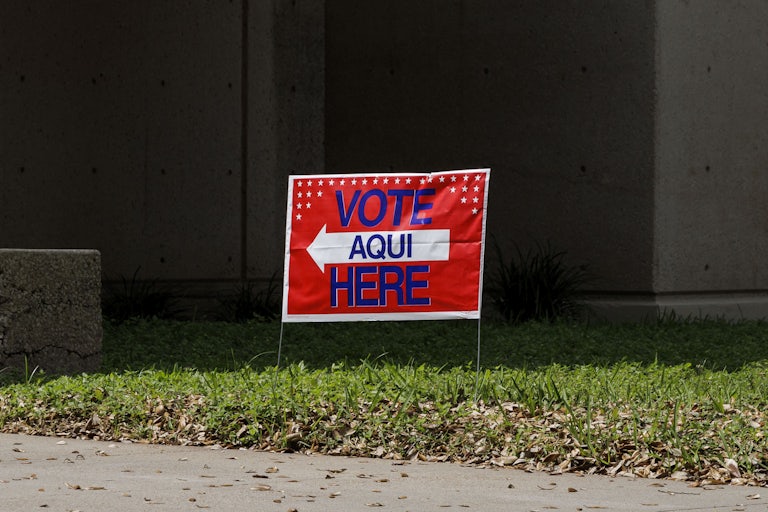 A sign outside a polling station that says, "Vote Aqui/Here"