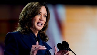 Kamal Harris gestures while speaking at a microphone.