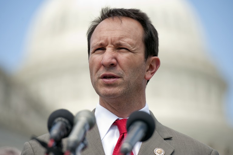 Louisiana Governor Jeff Landry squints as he speaks into microphones