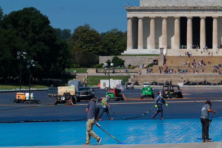 Workers paint the bottom of the Reflecting Pool