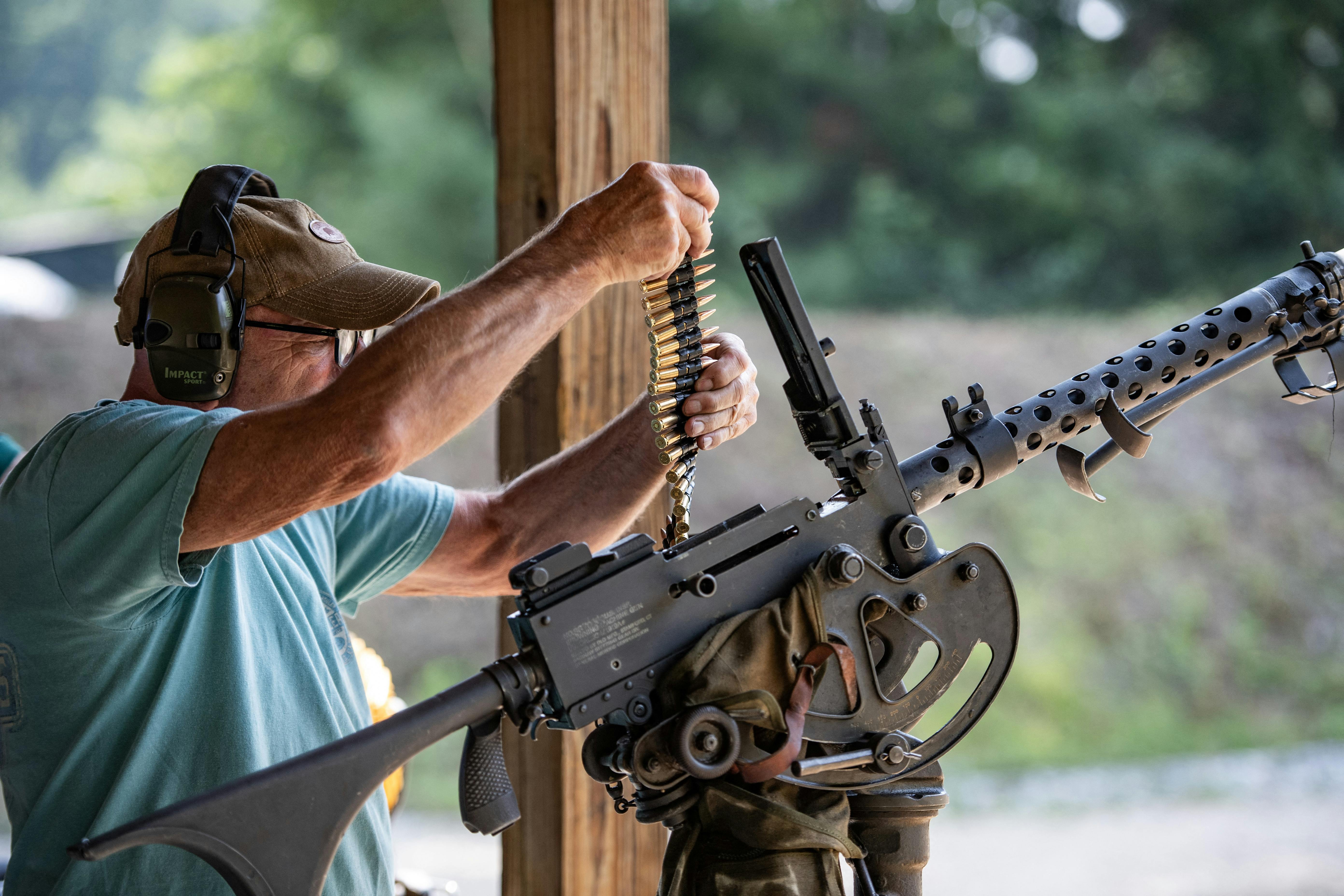 A man loads bullets into a machine gun during the Hillsborough County Republican Committee Sixth Annual Full-Auto Machine Gun Shoot in Litchfield, New Hampshire, on July 27, 2024. 