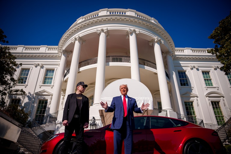 Donald Trump gestures and speaks as he and Elon Musk stand in front of a red Tesla Model S parked outside the White House