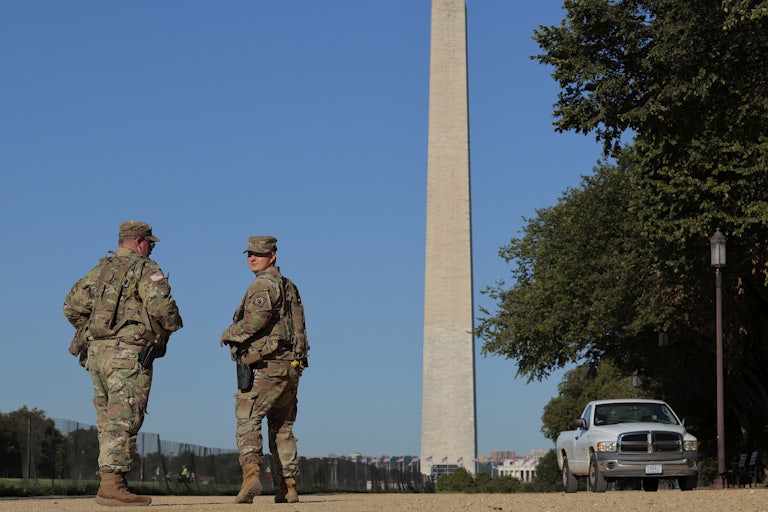 Members of the National Guard walk by the Washington Monument