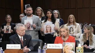 Epstein survivors and family members stand behind former Attorney General John Ashcroft and Jeffrey Epstein survivor Dani Bensky as she speaks during the second day of acting Attorney General Todd Blanche’s Senate Judiciary Committee confirmation hearing on July 16.